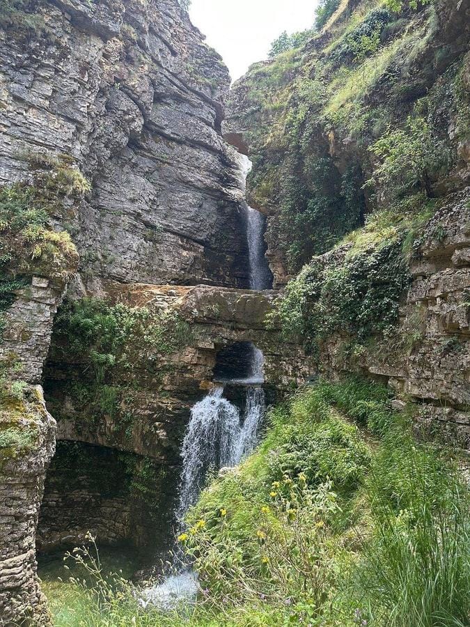 Peshtura Waterfall cascading through lush forest canyon